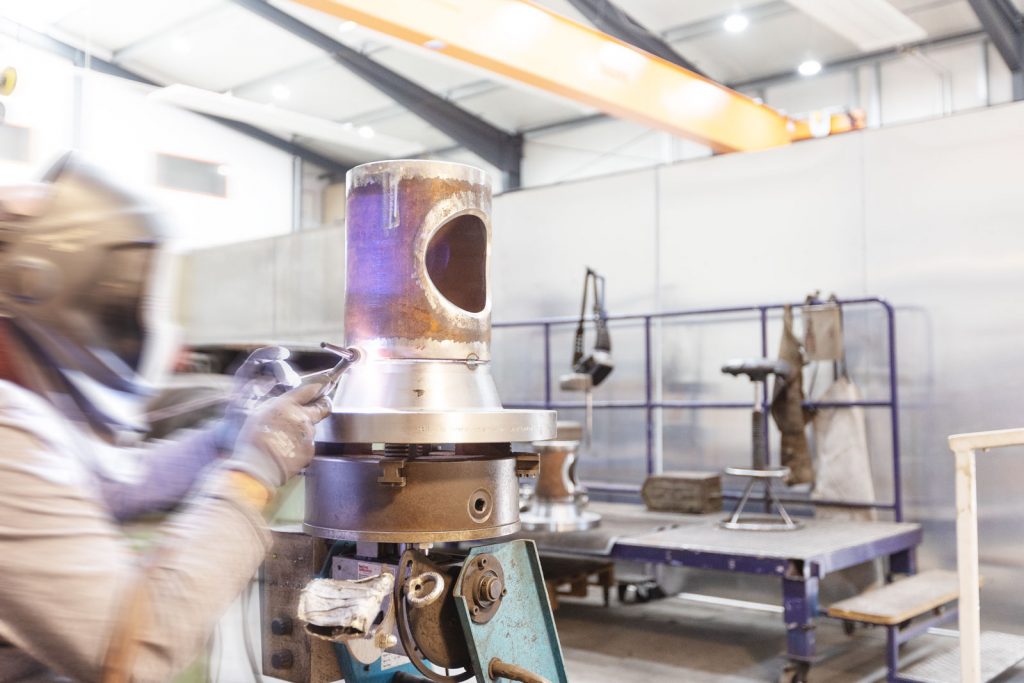 Isolierfabrik - Industriefabrik Schneider GmbH - Siebkorbfilter im Bau durch einen Schweißer, SKF, Konstruktion, WIG Schweiverfahren, Fertigung, Anlagenbau, Industriefilter, Filterbau Armaturentechnik, Rohre, Flansche, Edelstahl, Armaturenmodifikation, Industrieanlagen